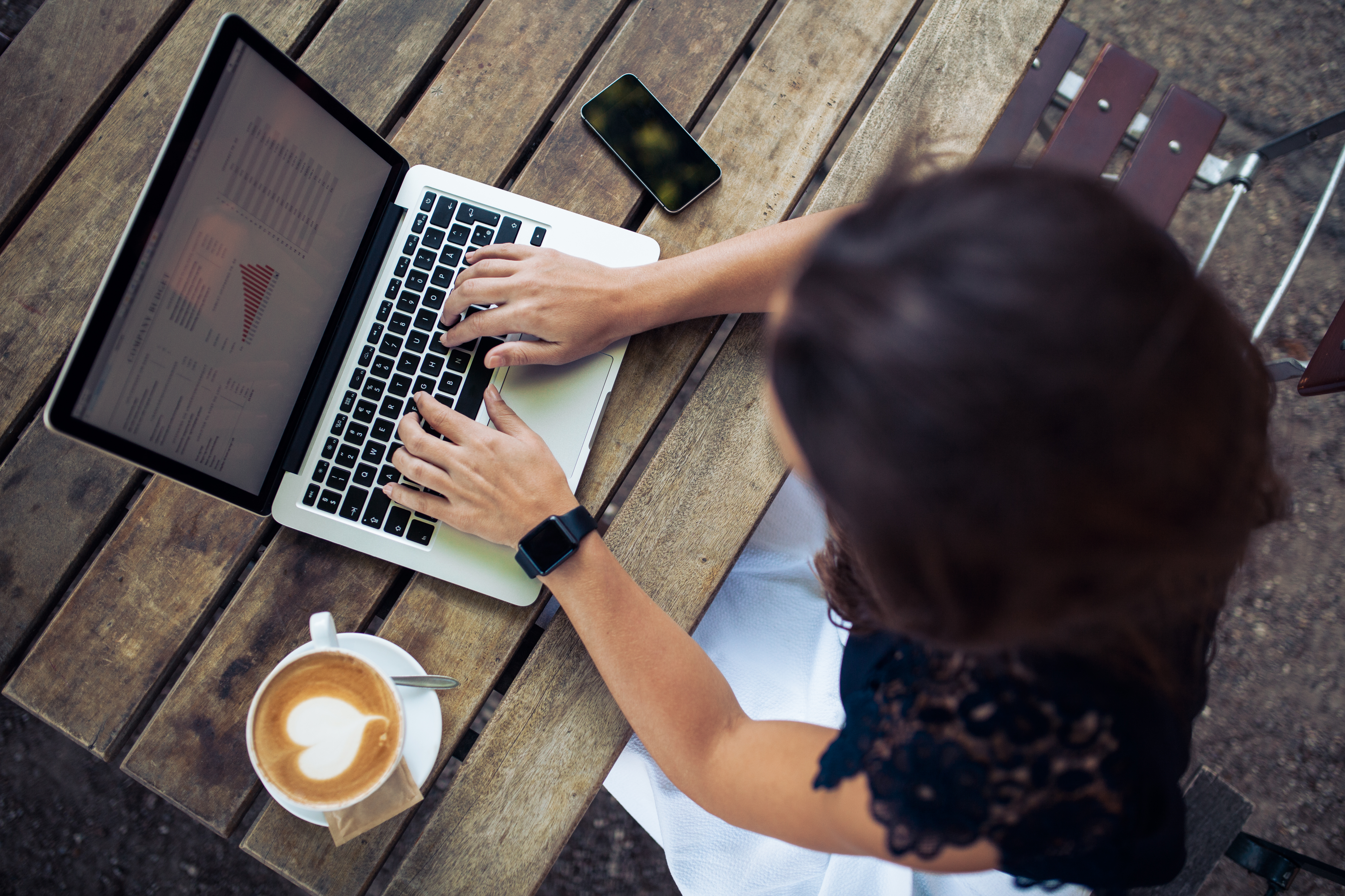 Kvinna sitter med en laptop på ett café